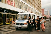 在城市街道上，一群人正在一辆警车附近互动，这一场景被拍摄下来