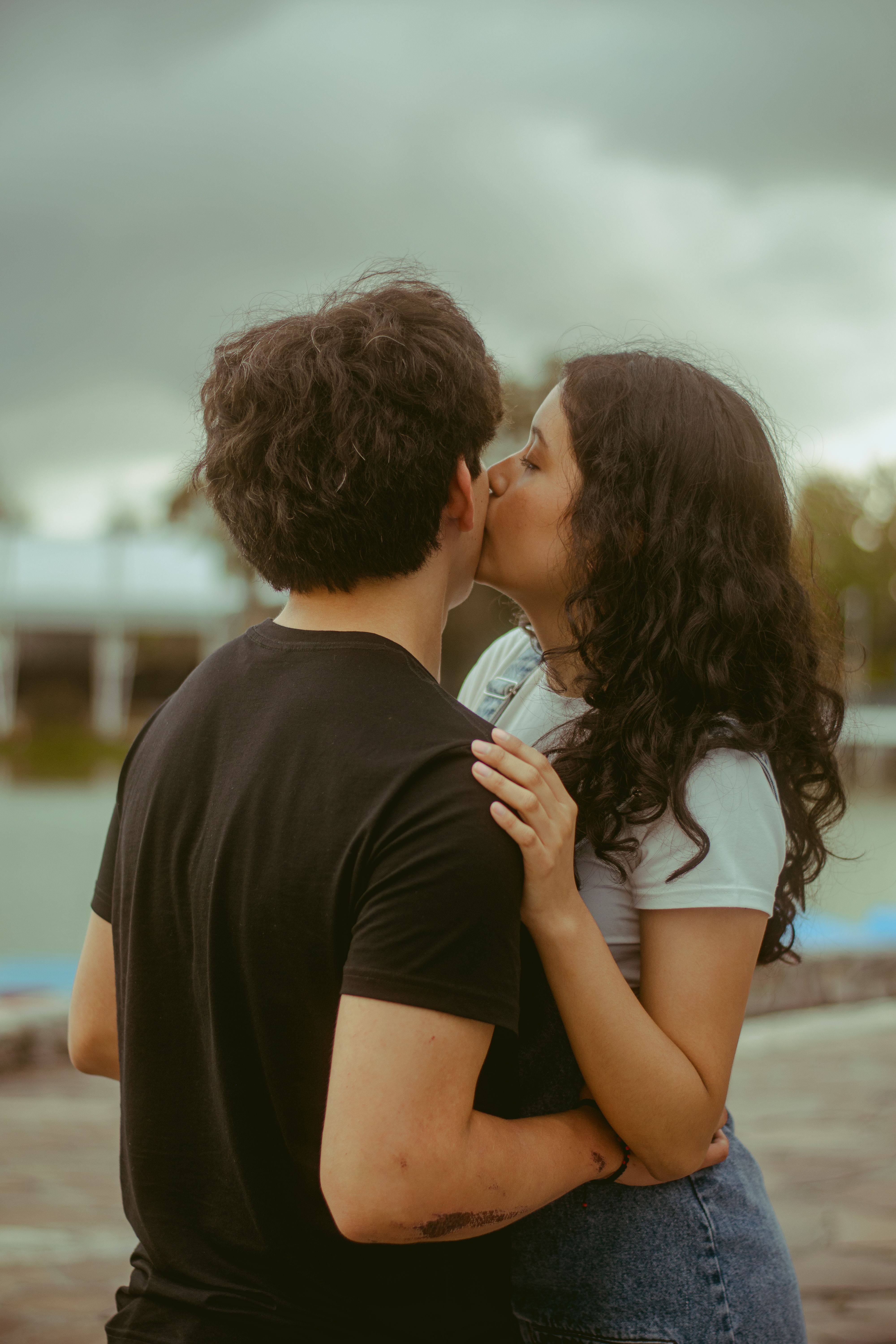 Romantic Outdoors Couple Sharing a Tender Kiss · Free Stock Photo