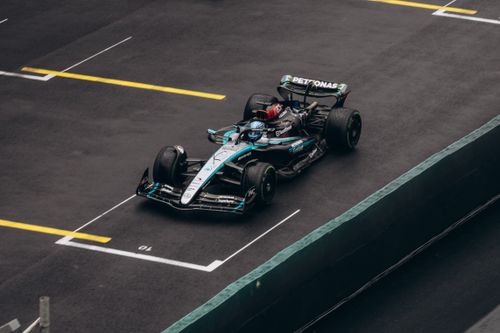 Free Dynamic shot of a Formula One car racing on wet asphalt, showcasing speed and precision. Stock Photo