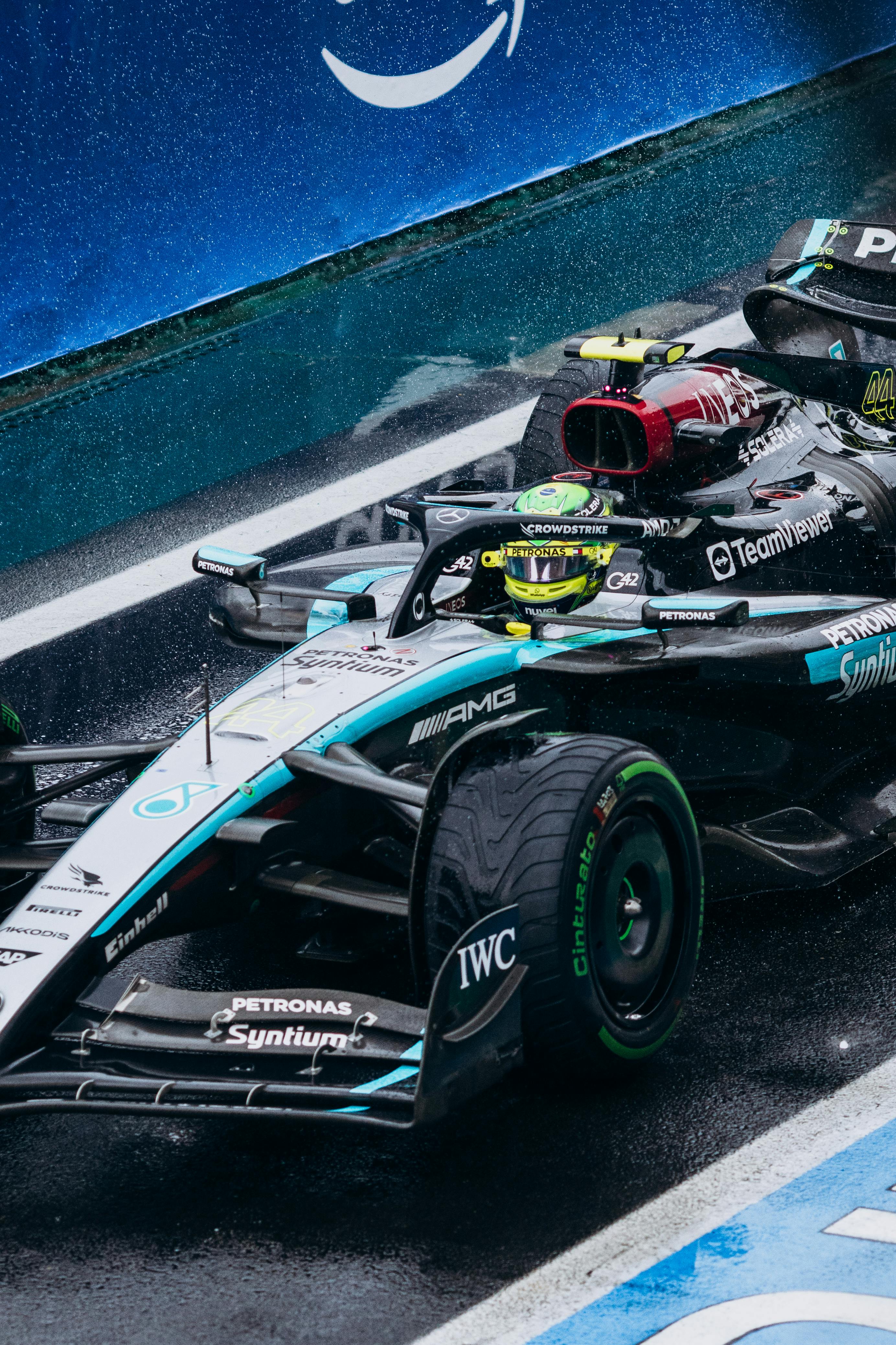Close-up of a Formula One race car on wet track, showcasing speed and precision.