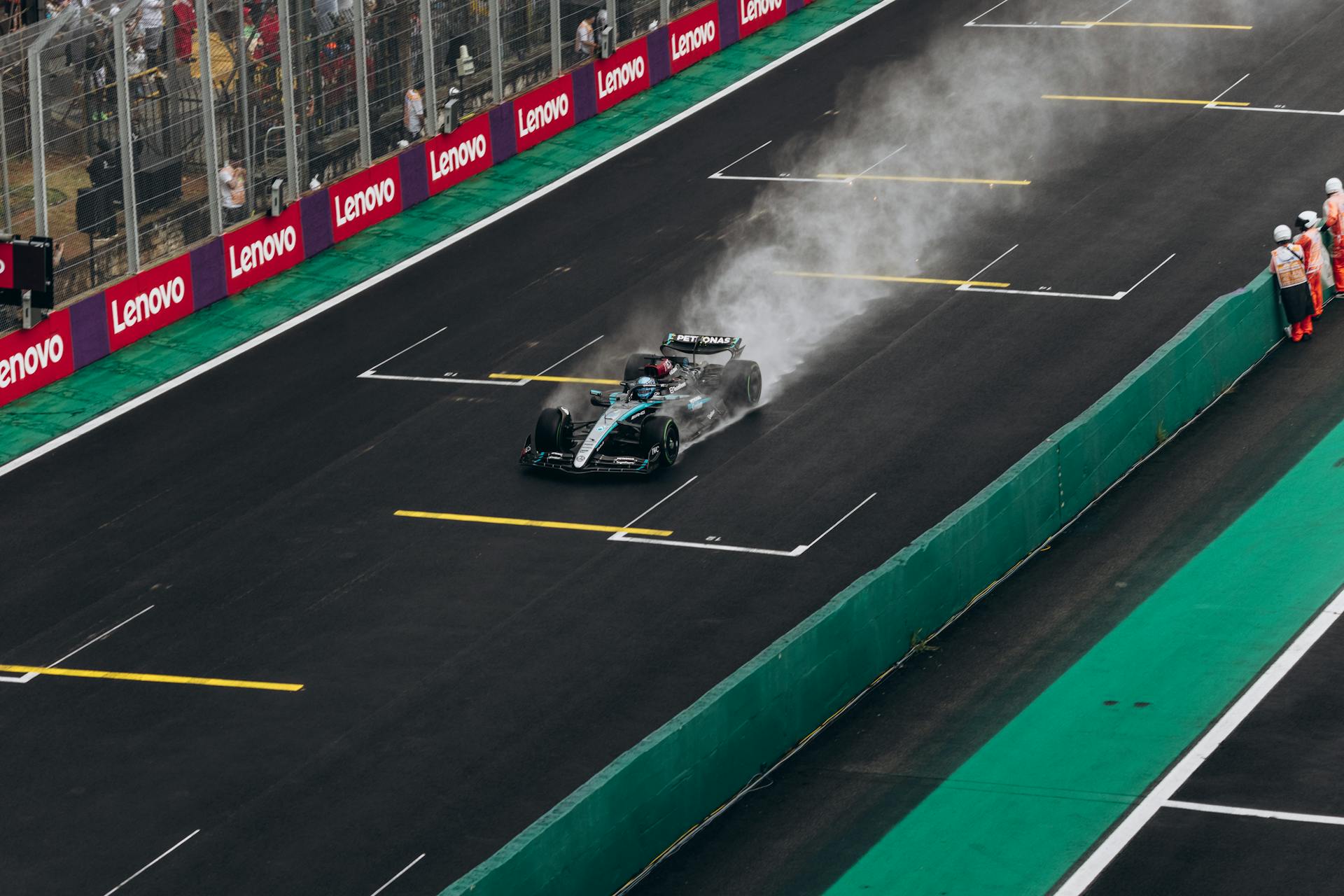 Formula 1 car speeding on wet track during race. High-energy motorsport action.