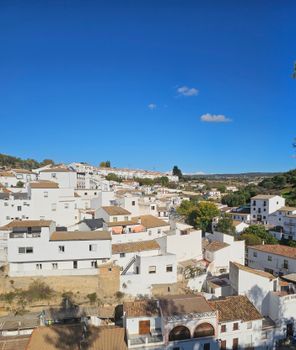 A picturesque view of an Andalusian white village under a bright blue sky, showcasing traditional architecture.