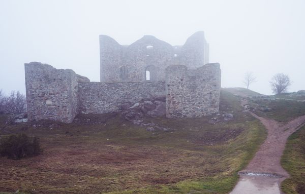 Ruined stone fortress in mist — photo by Damir K. on Pexels