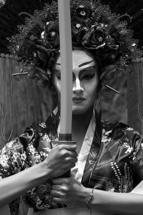 Free Black and white portrait of a traditional Japanese warrior in elaborate costume holding a sword. Stock Photo