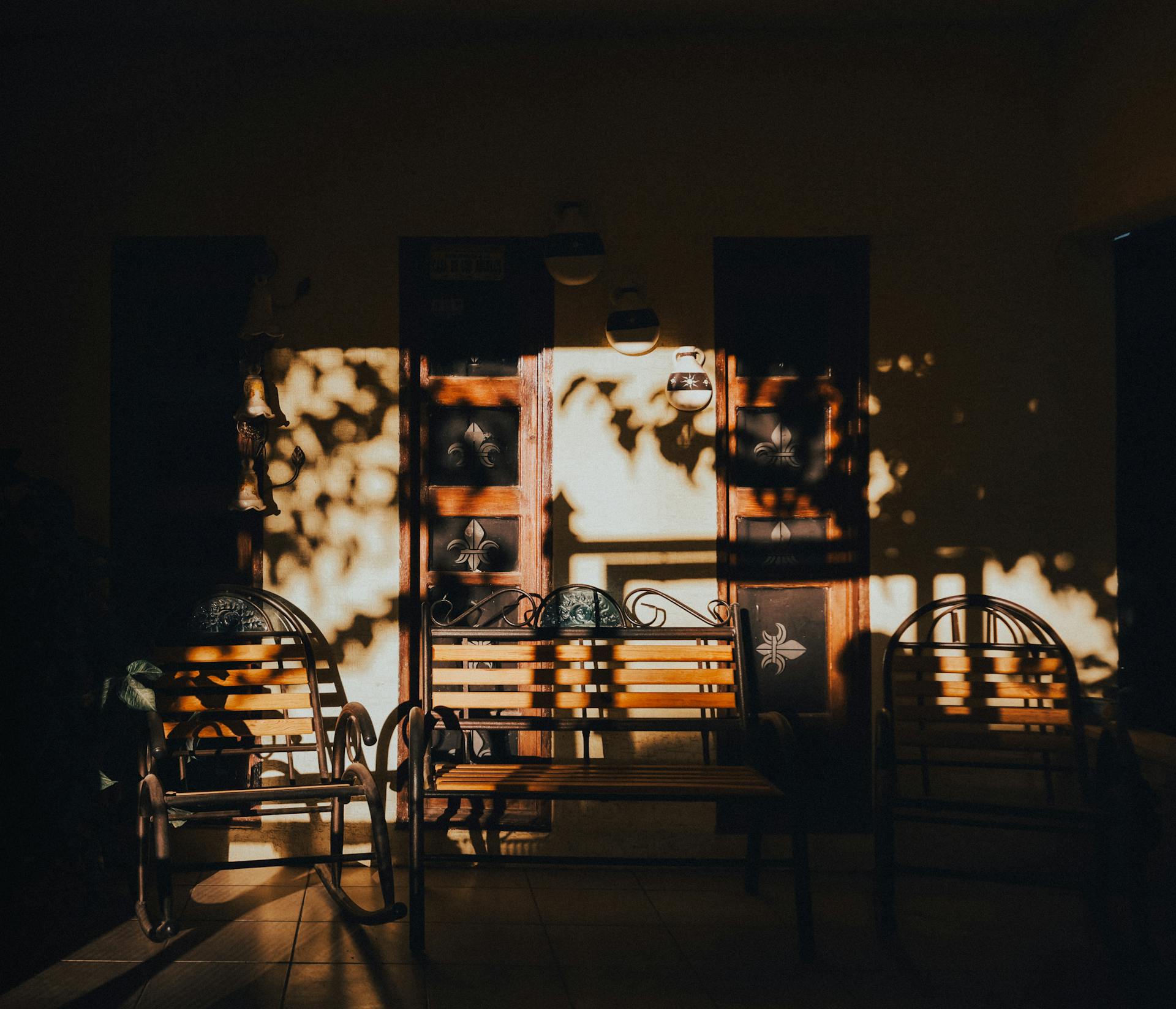A sunlit porch in Mexico with shadows creating a dramatic and moody atmosphere.