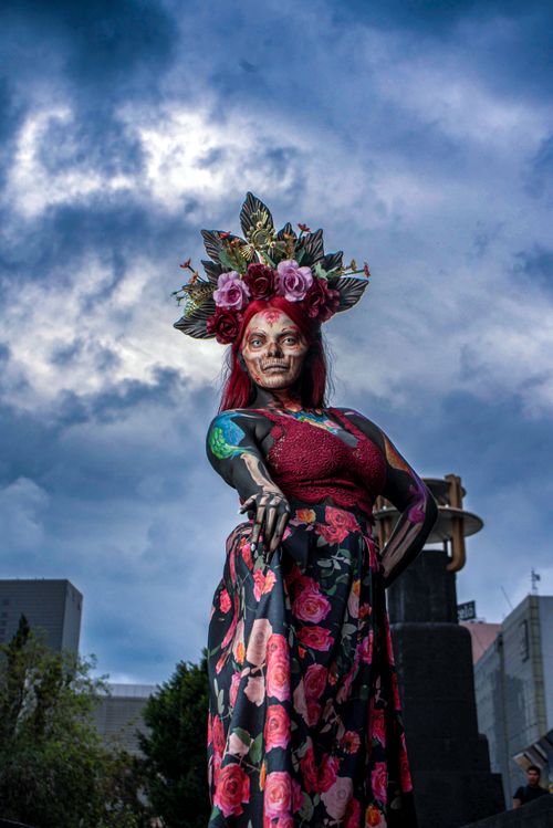 Free Colorful portrait of a woman dressed in floral attire against a cloudy sky. Stock Photo