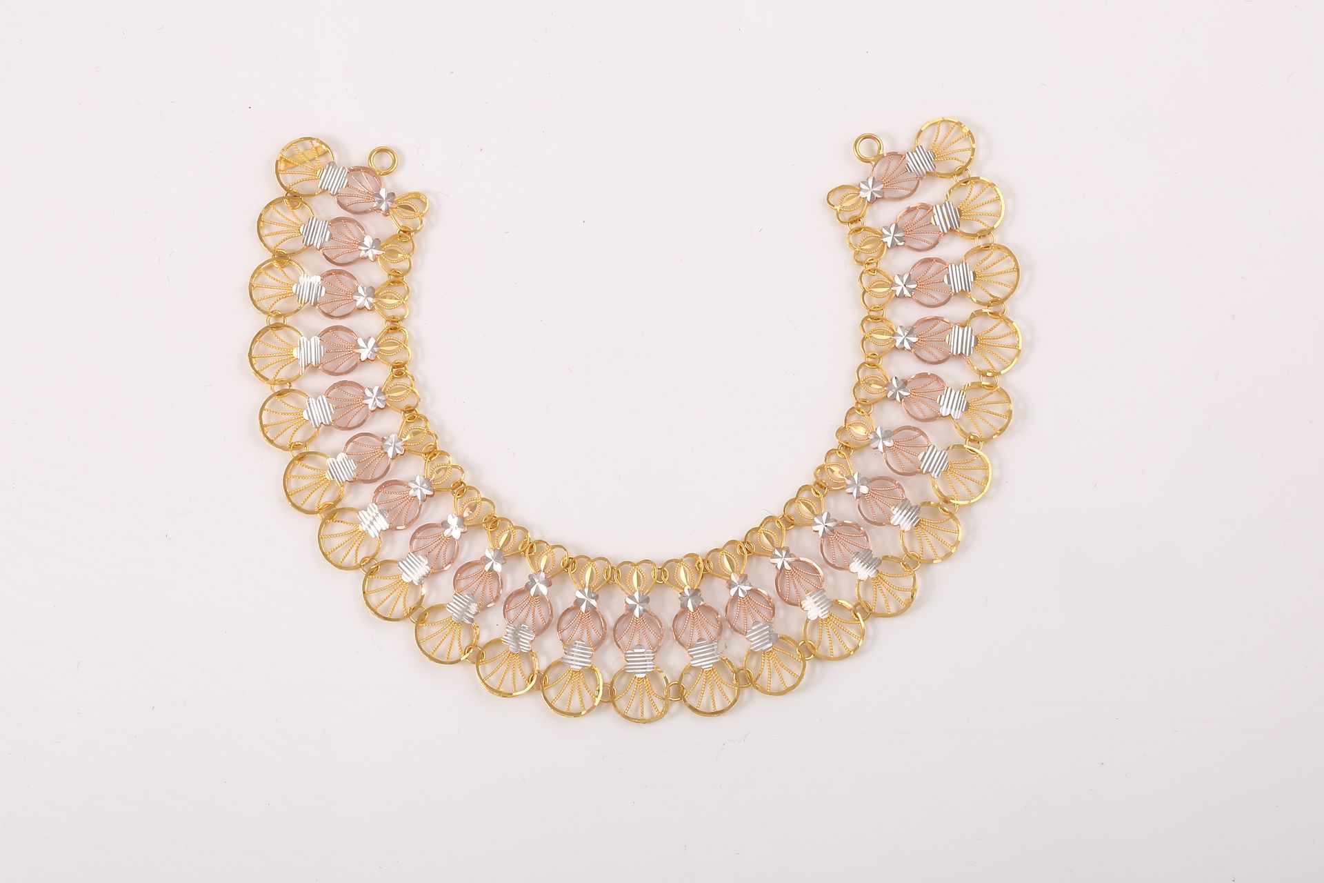 Sophisticated gold and silver necklace showcasing intricate design on a clean white surface.