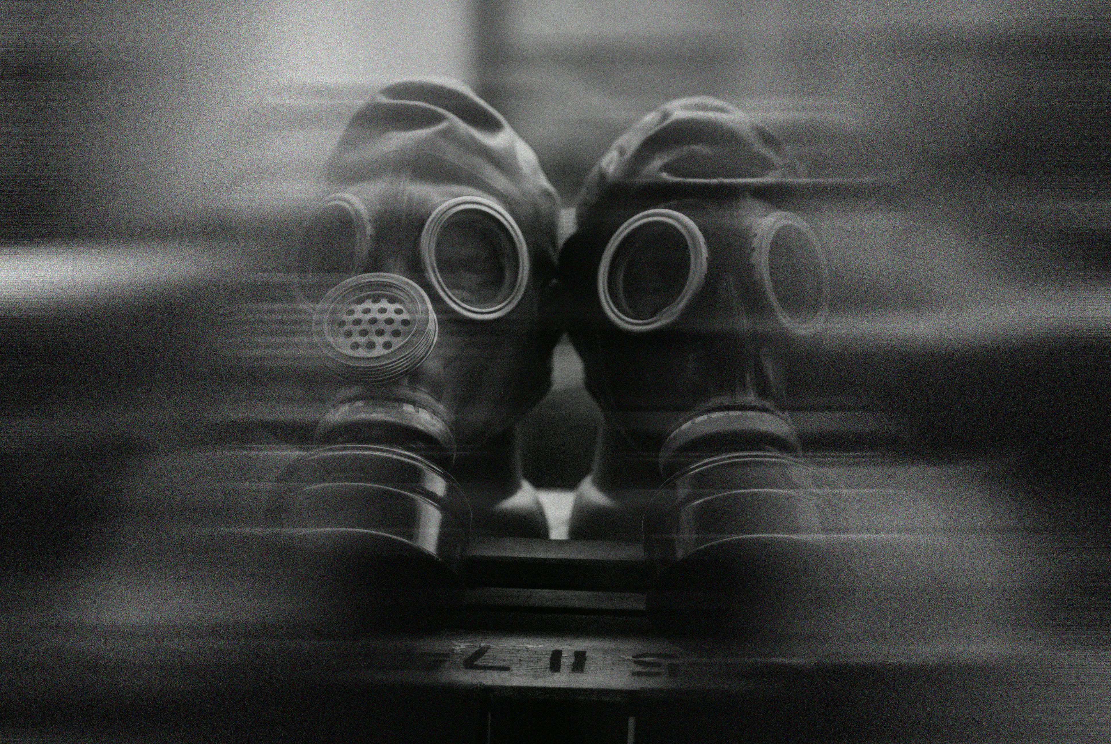 Free Two gas masks captured in a surreal, blurred black and white image. Stock Photo