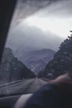 Wintry road through snowy Bakuriani mountains captured from a vehicle view.