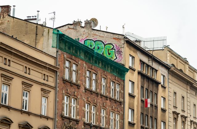 Colorful graffiti on historic buildings in Kraków, Poland, showcasing urban art contrasting old architecture. — arriving in Balice