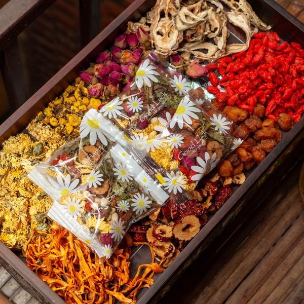Dried botanicals and flowers sorted into the compartments of a wooden box. Photo by Dang Hong on Pexels.