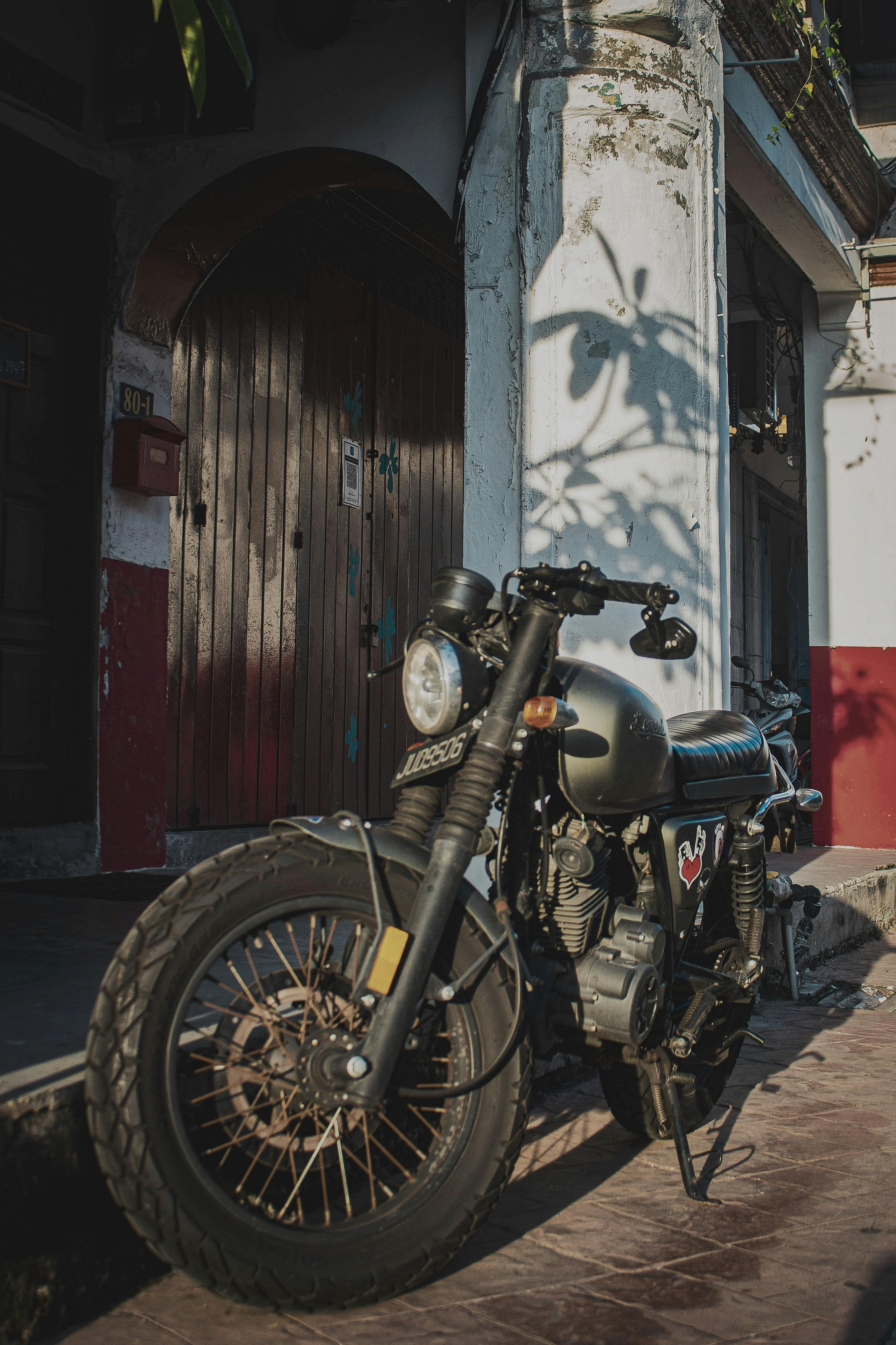 vintage motorcycle parked by rustic building