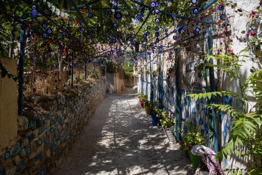 Picturesque alley adorned with traditional evil eye charms in Darende, Türkiye, during the daytime.