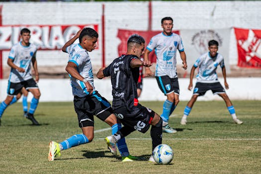 Intense soccer match with players in action on a sunny day.