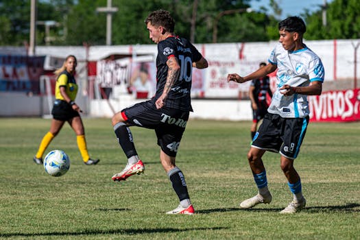 Exciting soccer match on a sunny day with players in action, showcasing dynamic gameplay.