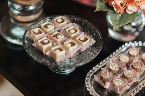 Free Close-up of assorted chocolates and petits fours on elegant glass trays, perfect for a luxurious dessert presentation. Stock Photo