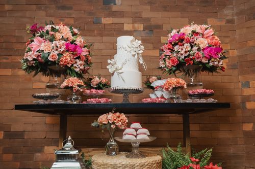 Free Beautiful wedding cake with vibrant flower arrangements on a rustic table setting. Stock Photo