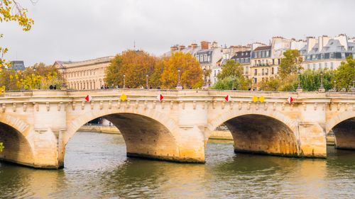 Free Scenic view of Pont Neuf and autumn foliage over the Seine River in Paris, France. Stock Photo