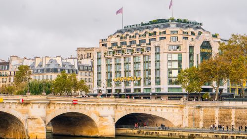 Free Elegant architecture and bustling life at Pont Neuf along the Seine River in Paris, France. Stock Photo