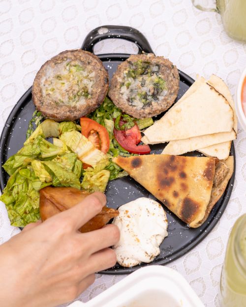 Free Appetizing Mediterranean platter featuring vibrant salads, fresh bread, and stuffed dishes on a decorative table setting. Stock Photo