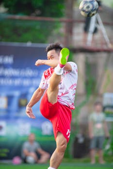 Soccer player executing a powerful kick on a vibrant field in Hanoi, Vietnam.