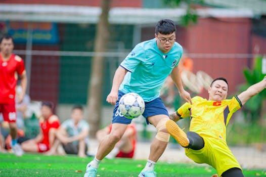 Dynamic action shot of a soccer tackle during a match in Hanoi, Vietnam.