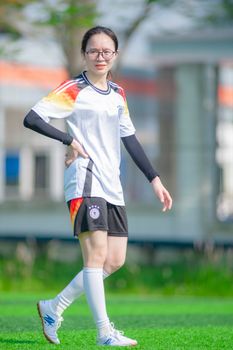 A young woman playing soccer outdoors in Hà Nội, Vietnam.