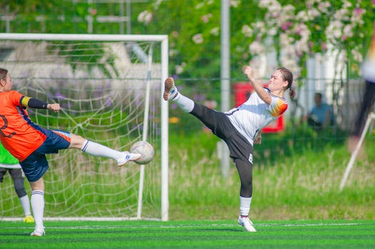 Action shot of women playing soccer on a sunny day in Hanoi.