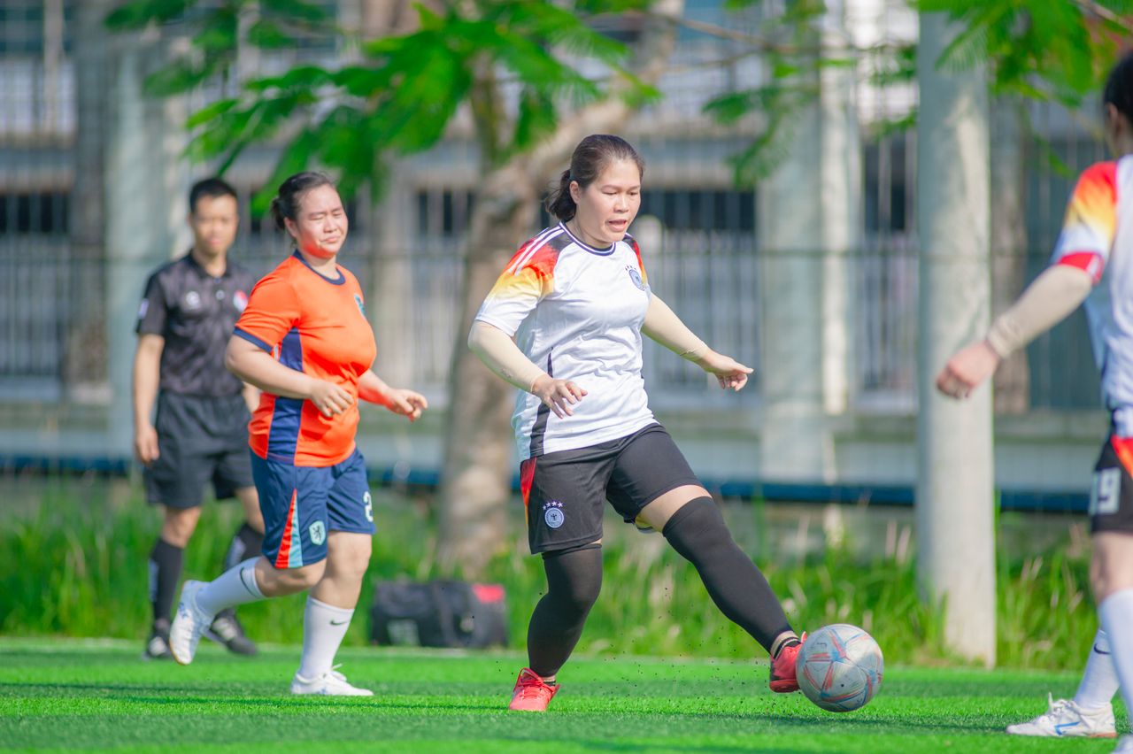 women engaged in a friendly soccer match on a sunny field in h n i vi