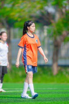 Young female soccer player in action on a sunny day, Hanoi, Vietnam.