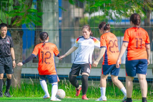 Women playing football at a pitch in Hanoi, showcasing teamwork and sportsmanship.