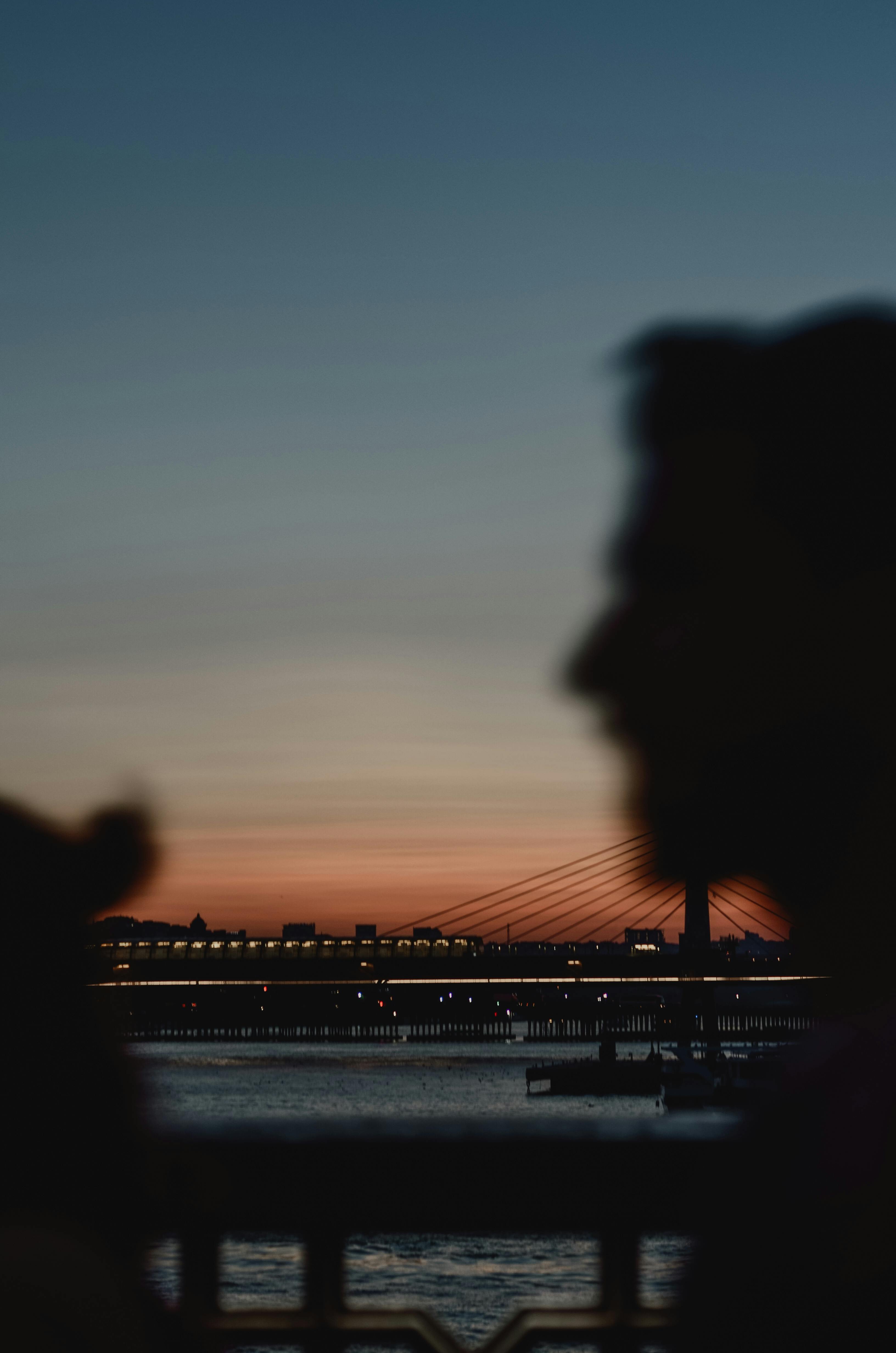 日落时分，河上的城市桥与人们的剪影共同营造出一片宁静的景象