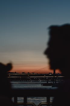 日落时分，河上的城市桥与人们的剪影共同营造出一片宁静的景象