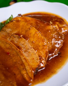 Succulent slices of roast beef covered in a rich, savory gravy.