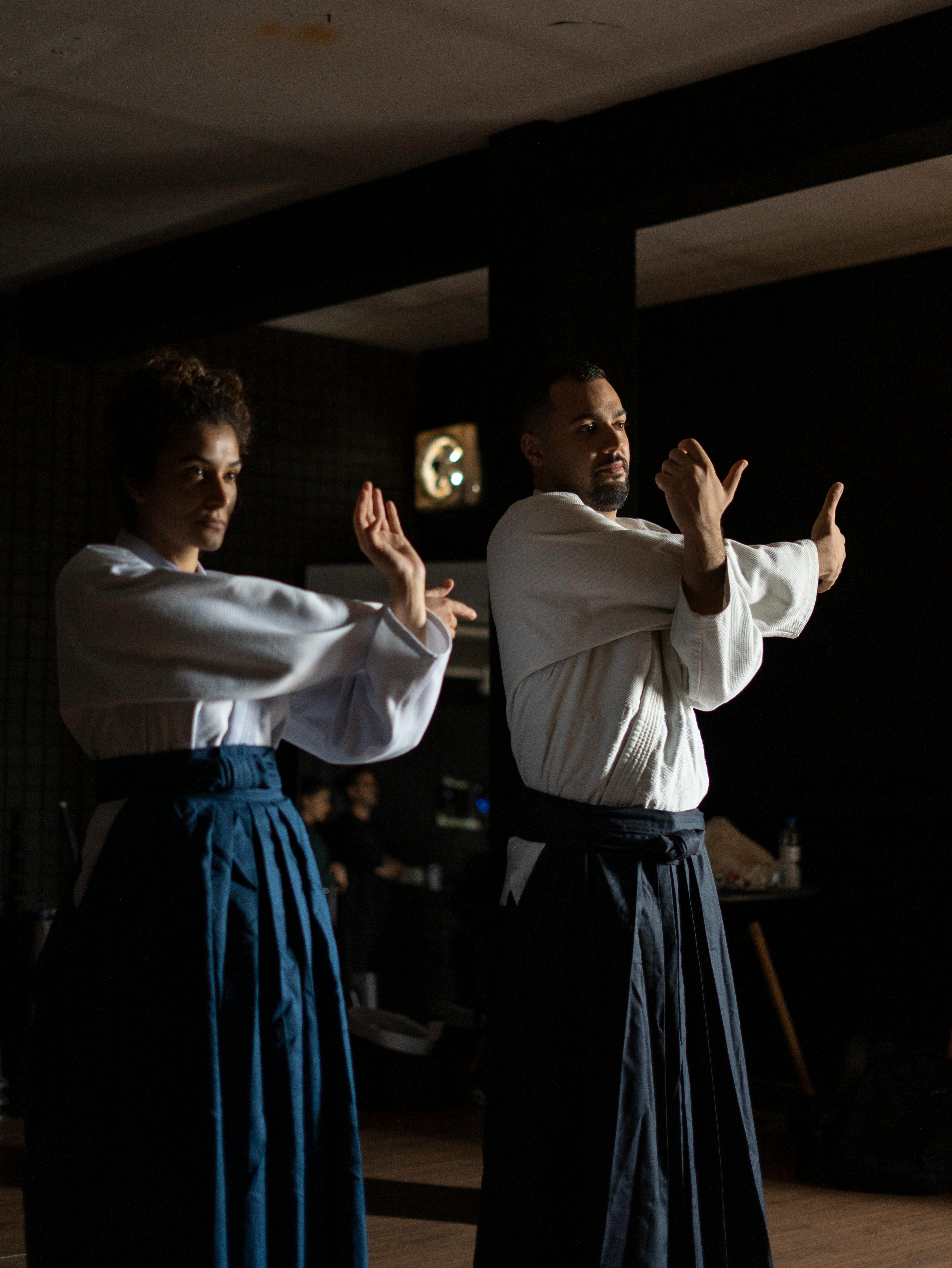 Two martial arts practitioners training together in traditional attire demonstrating Wing Chun techniques