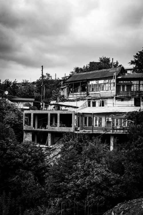 Free Monochrome image of urban buildings and vegetation in Georgia, showcasing architectural contrast. Stock Photo