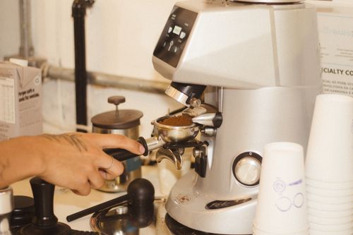 Free Close-up of a barista using a coffee grinder to prepare fresh espresso. Stock Photo