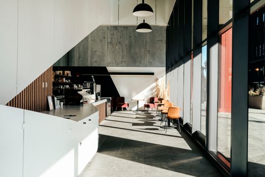 Sunlit modern café interior with minimalist decor and large windows. Perfect space for relaxation or meetings.