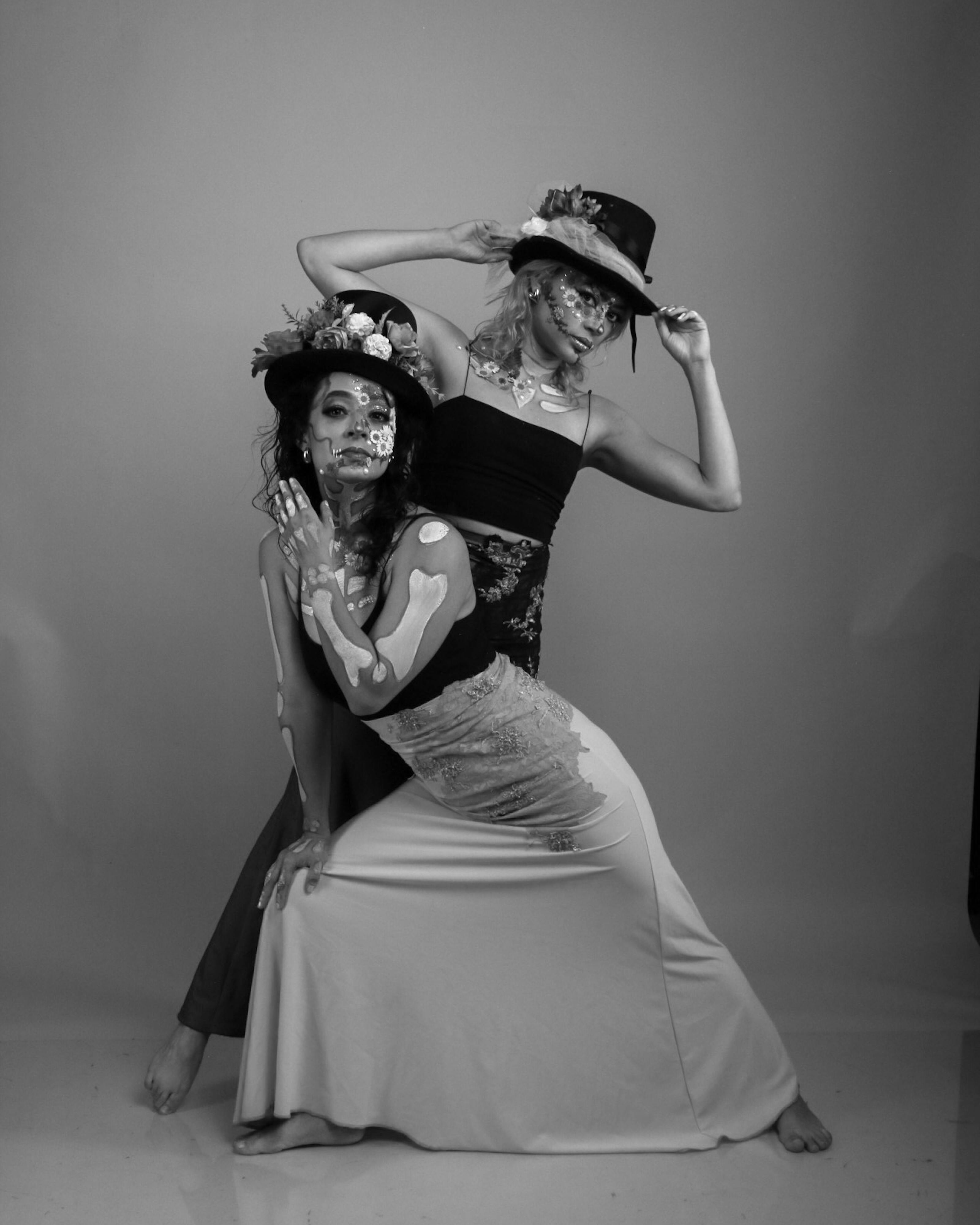 Ücretsiz Benzersiz yüz boyaları ve çiçekli başlıklarla yaratıcı pozlar veren kadınların siyah beyaz sanatsal portresi. Stok Fotoğraflar