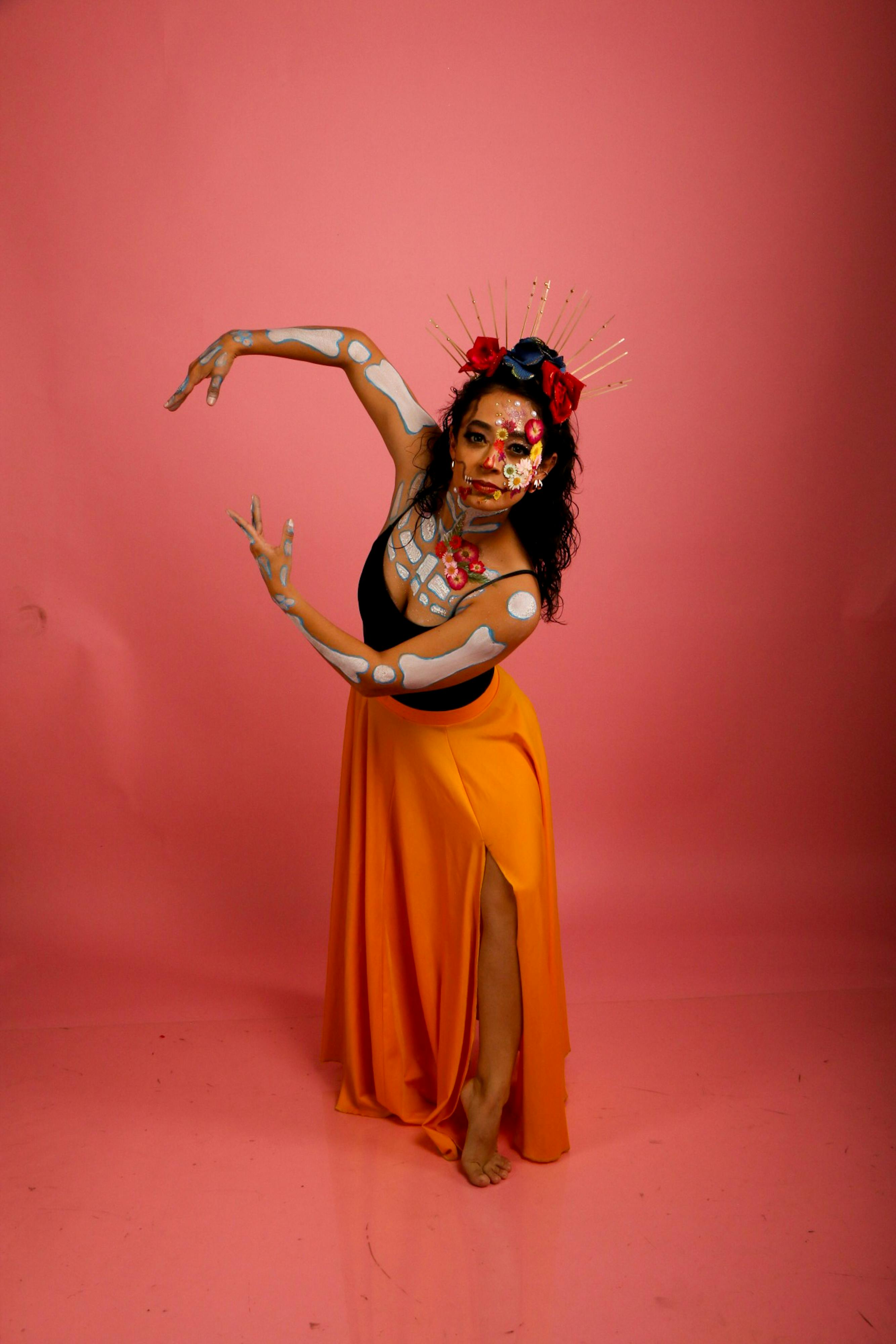 Ücretsiz Pembe bir arka plan önünde boyalı yüze sahip canlı kostümlü sanatçı dansçı. Stok Fotoğraflar