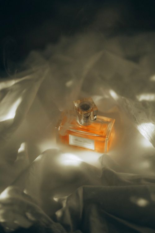 Free A captivating image of a perfume bottle surrounded by mystical mist, perfect for elegant themes. Stock Photo