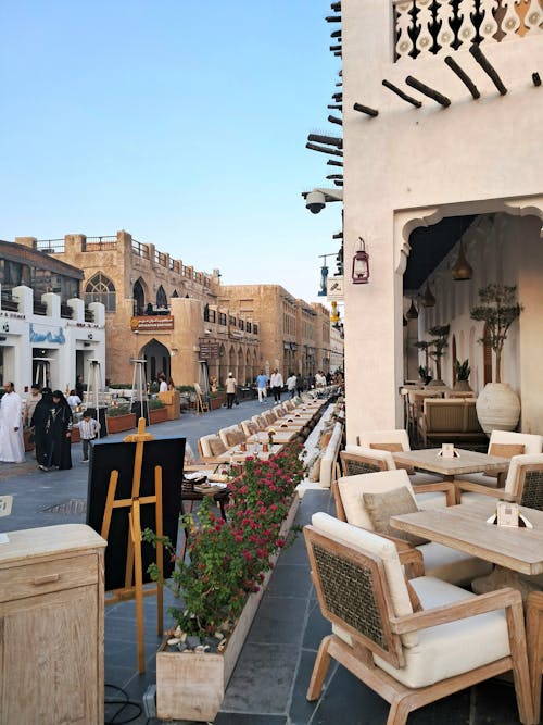 Free A lively street scene at Souq Waqif with traditional architecture and people gathered in Doha, Qatar. Stock Photo سوق واقف