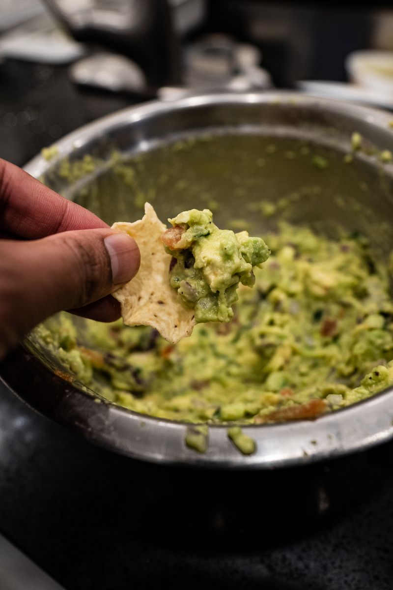 Tortilla chip dipped in fresh guacamole