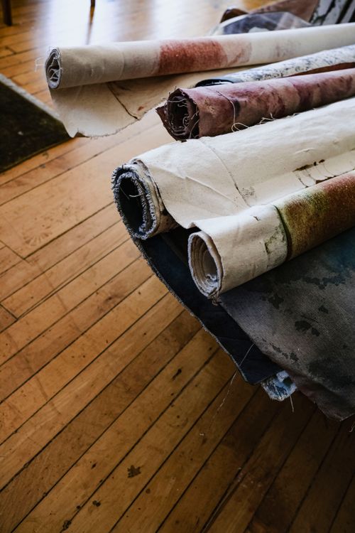 Free Colorful fabric rolls laid out on a wooden floor, showcasing texture and patterns. Stock Photo
