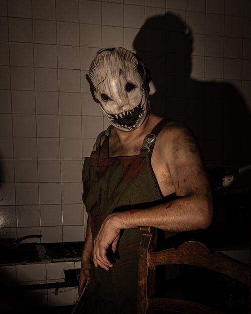 Free Creepy Halloween cosplay featuring a terrifying mask and eerie atmosphere indoors. Stock Photo