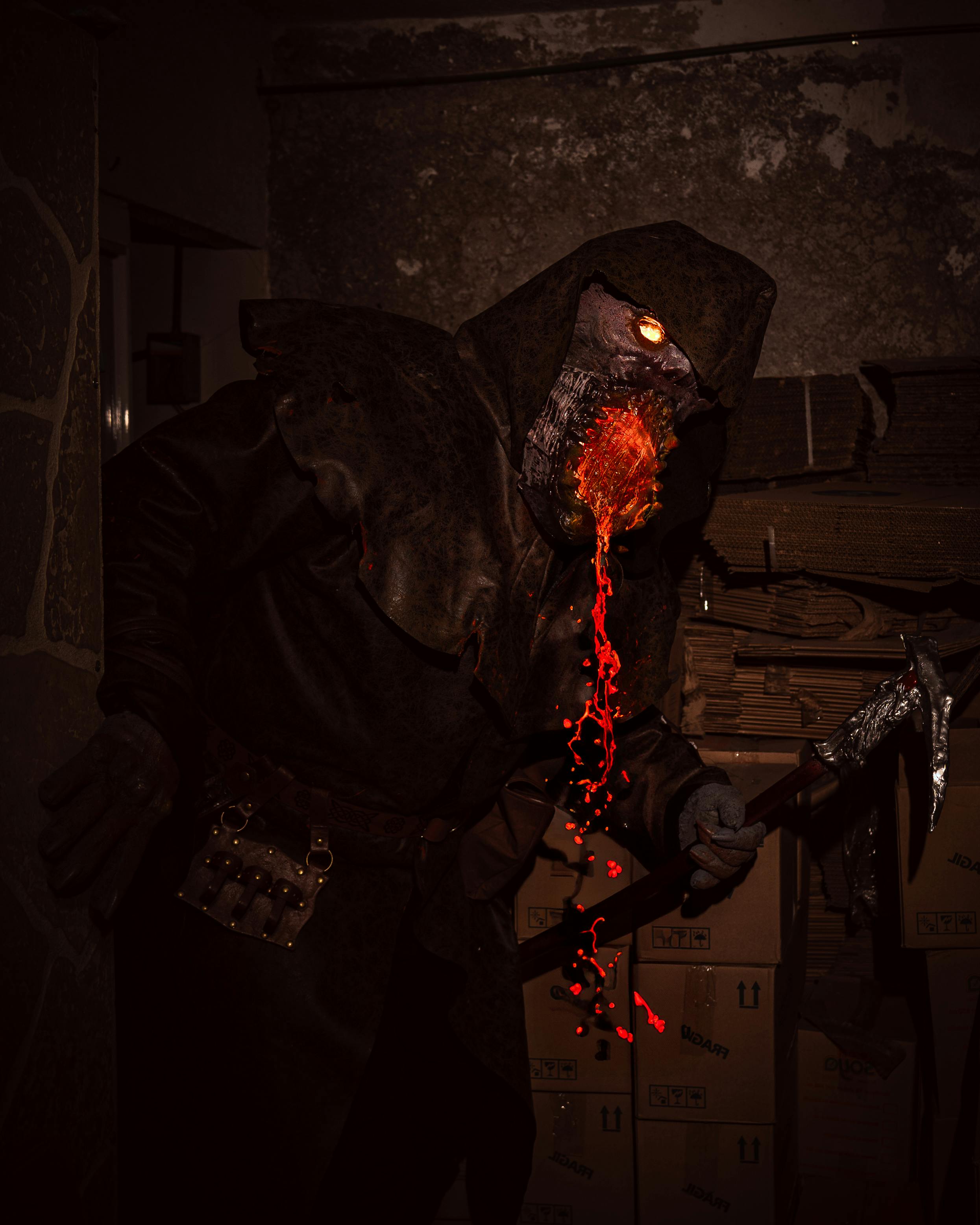 A frightening monster costume with glowing effects and special makeup in a dimly lit room for a horror themed event.