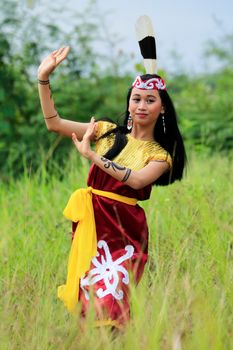 A woman in traditional attire performs a cultural dance outdoors. - Fotografer Sidoarjo