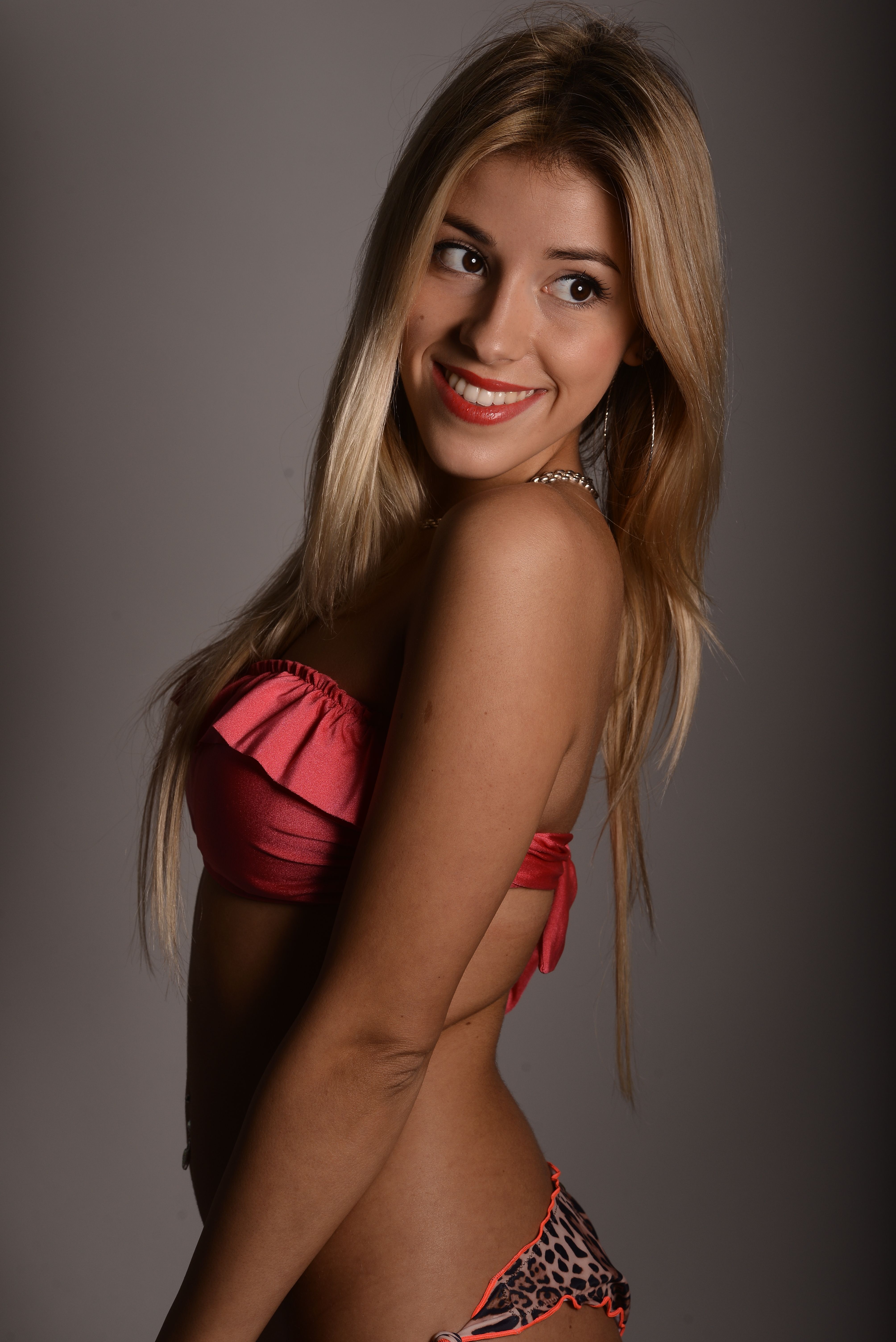 Confident woman with long blonde hair smiling in a stylish bikini.