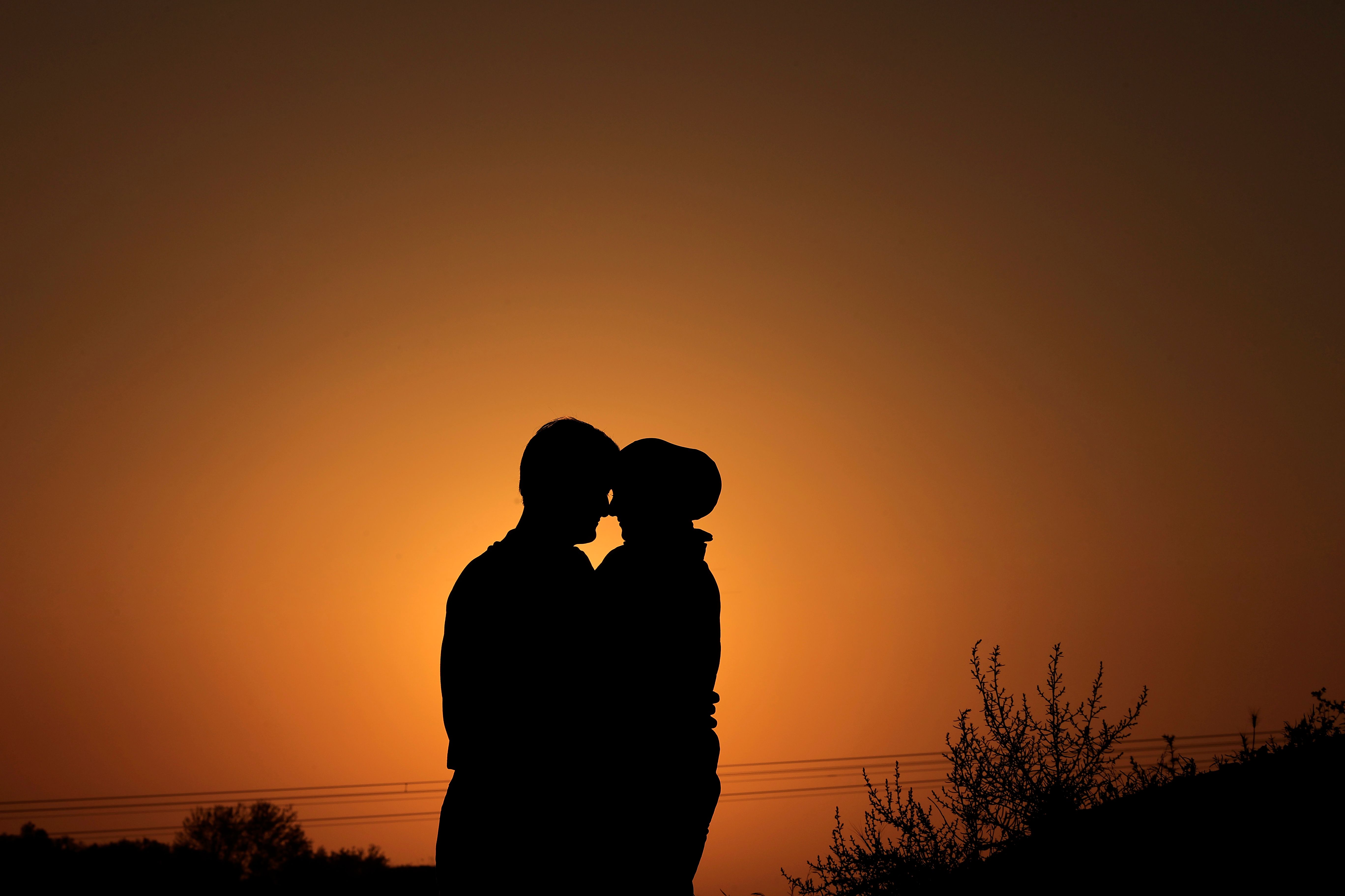 Silhouette of Couple Embracing at Sunset · Free Stock Photo