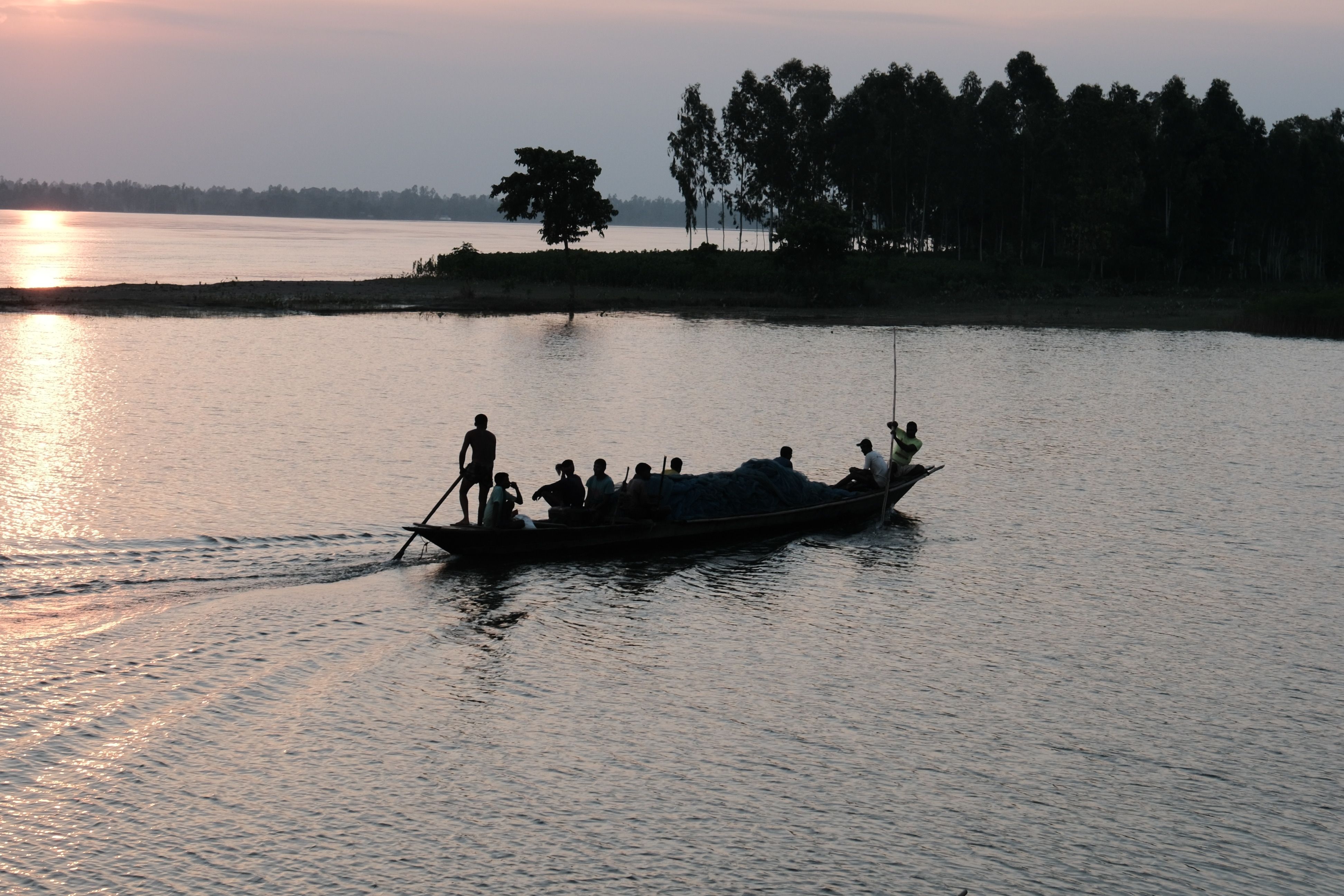 Silhouetted Fishermen on a Boat During Sunset · Free Stock Photo